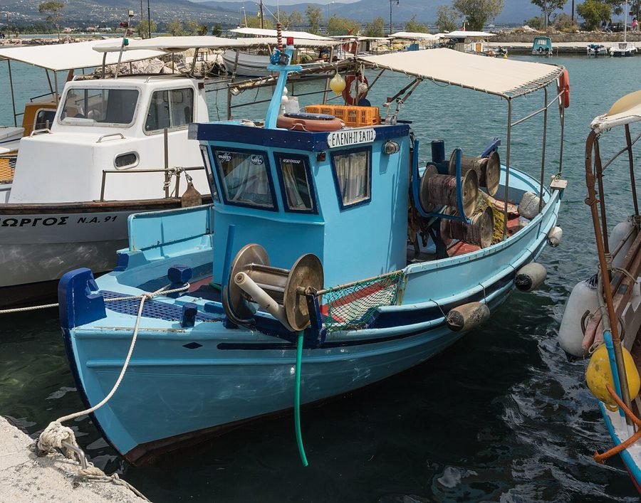 Small fishing boat with nets moored in a harbour